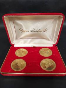 lot 588 image: Vintage Olympian Medallion Set Four Gold-Tone Commemorative Coins