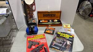 lot 1018 image: Hoppes deluxe gun cleaning kit appears new, headphones, ear plugs and 2 books
