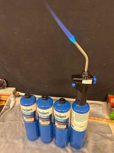 lot 25 image: Bernzomatic Propane Torch Kit with 4 Propane Cylinders the three tanks on left feel full, one with torch feels used obviously