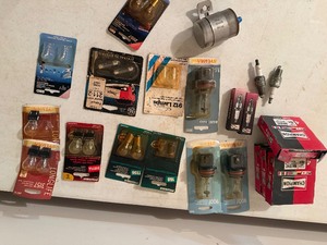 lot 100 image: Mixed Automotive Parts Lot  Sylvania Bulbs, Champion Spark Plugs, Fram Filter