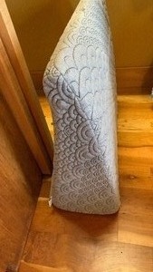 lot 1547 image: Wedge pillow with a quilted white cover and gray fabric sides.This wedge pillow is designed for lounging, reading in bed, or elevating your legs to improve circulation. 23X23