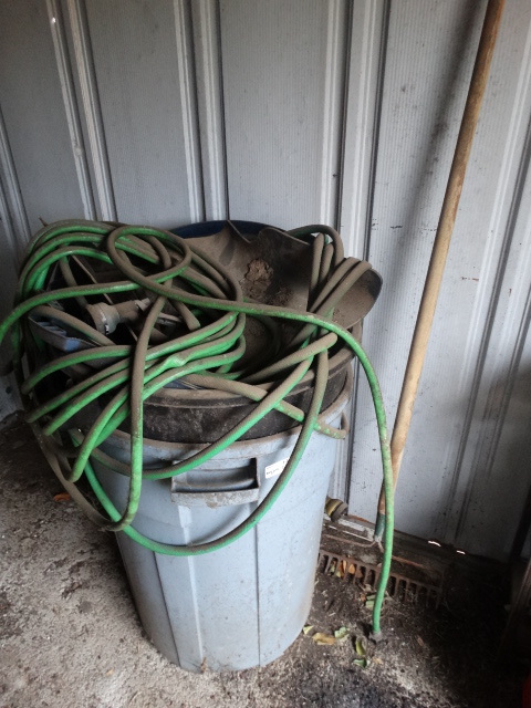 lot 14883 image: 2 Trash cans and a water hose.