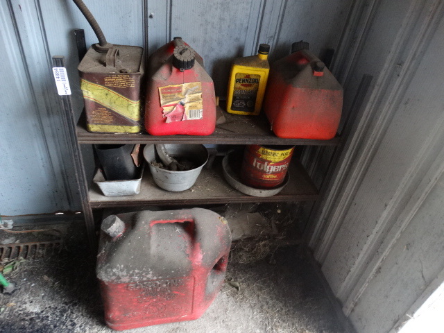 lot 14884 image: Small metal shelf with various size gas cans and small metal buckets.