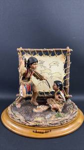 lot 17 image: Native American Heritage Collection LITTLE BUFFALOS STORY Blackfoot Polyresin with Leather Detailing Approximately 8 inches tallCertificate of Authenticity included