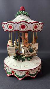 lot 34 image: Adorable Great Display Piece 12 Inch Tall Home for the Holidays Porcelain Christmas Carousel Music Box with Santa and Reindeer. (Will need Repair to Play Here Comes Santa Claus, and Spin)