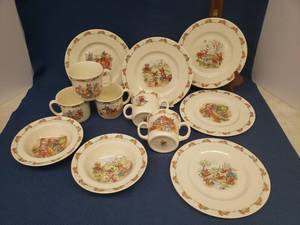 lot 84 image: Vintage 1936 Royal Doulton - English Fine Bone China - Bunnykins Pattern Dinnerware with Various Bunny Scenes Five 8in Plates, Two 6.5in Bowls, Three Coffee Cups 3in T, and Two Double Handle Mugs 3in T