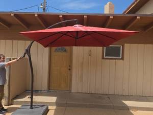 lot 80 image: Red Cantilever Offset Patio Umbrella with Base (see pics for damage)
