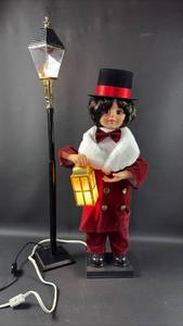 lot 2 image: New Electric 24 Inch Animated Christmas Caroler Boy Doll with Lantern and Street Lamp