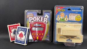 lot 115 image: Gaming and Toy Collection - Bicycle Playing Cards, Pocket Poker Electronic Game, and Lowes Coin Bank Build Kit