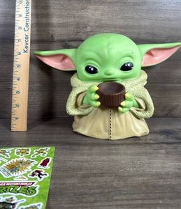 lot 111 image: Baby Yoda Grogu Coin Bank with TMNT Sticker Sheet