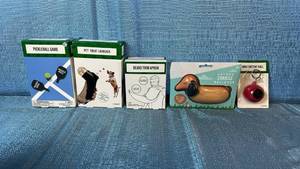 lot 2154 image: Novelty Gift Bundle - Pickleball Game, Pet Treat Launcher, Beard Trim Apron, Hot Dog Stress Ball, Mini Fortune Ball