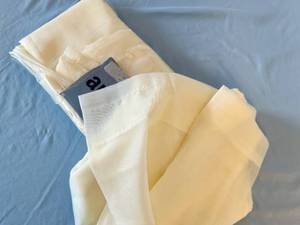 lot 137 image: Pair of off-white sheer curtain panels with warm yellow undertones, 52 W x 108 L - Retail $25