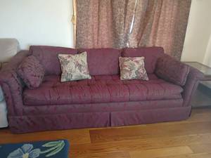 lot 906 image: Maroon Colored Couch with Hide a Bed.  Has a floral pattern with throw pillows.  25 x 83 x 34