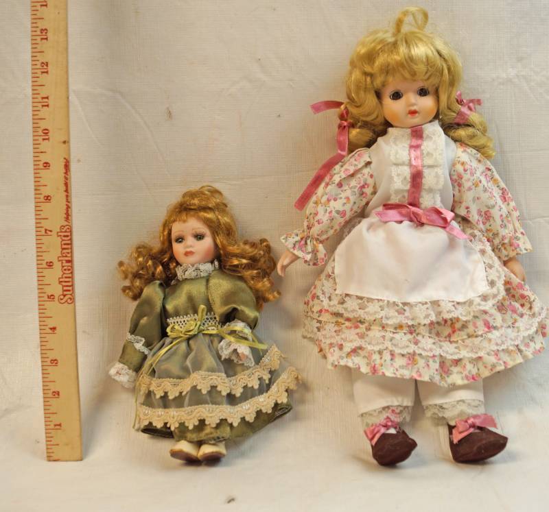 lot 6281 image: Two pretty porcelain dolls. One with a music box in her belly-See pics for sizes. Cute and musical