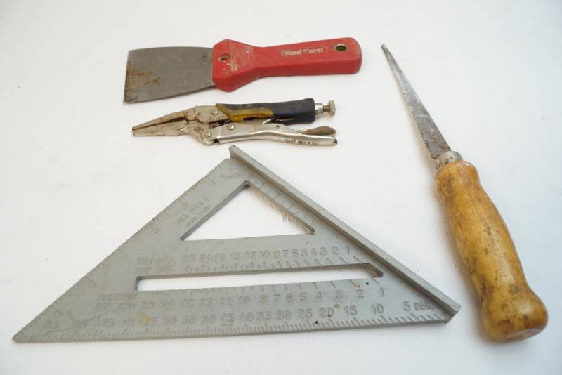 lot 5050 image: Lot of four tools- putty scraper, small saw, square, needle nose vice grips