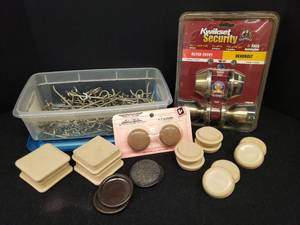 lot 33 image: Kwik Set Security Keyed Entry Deadboat Set Unopened  in Package, Furniture Sliders & Carpet Cups, & Tub of Peg Board Hooks - Various Sizes