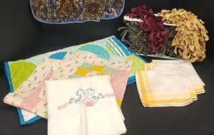lot 13 image: Sewing Supplies & Handwork Embroidery, Quilt Squares, Hand Made Apron, Quilted Changing MatPillow Case, Vintage Cloth Napkins, and Collection of Unused Tassel & Braid Trim