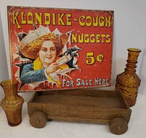 lot 57 image: Vintage Hand Made Wood Wagon Table Tray 14in L x 7.25in W x 3.5in T, 1960s Amber Glass Decanter 10.25in T & Vase 6.5in T, and Vintage Style Metal Klondike Adverisement Sign 12.5 in T x 16in W