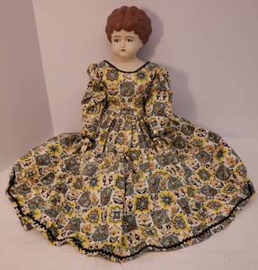 lot 61 image: Vintage Custom Made Ceramic Bisque Farm Girl Doll - Soft Body with Hand Made Dress, Shirt Slip, Petticoat, & Bloomers - Hand Painted Head, ArmsHands, and LegsFeet - Can Sit - Artist Signed & Dated 1970 on Back - 21in T