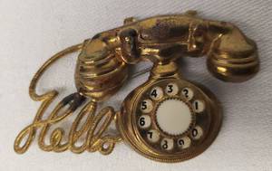 lot 77 image: Antique Pressed Brass Telephone Brooch with Hello written out with the Cord - Circa 1930s-1940s - Dial Actually Turns & has White Glass in Dial Center Setting - 2.75in L x 1.5in T
