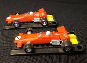 lot 92 image: Pair of Vintage 1970s Proctor & Gamble Funmate Plastic Auto Toys - 2 Formula 1 Race Cars - #7 Red, and 2 Rubber Band Action Launchers - They Work, but will need new bands