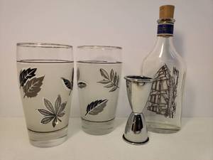 lot 123 image: Pair of Vintage 1960s Libby Frosted Silver Leaf Design High Ball Glasses - 5.25in T - Stainless Steel Double Jigger Bar Shot Measurer 3 58in T, and Captains Pride Ship Bottle 8in T