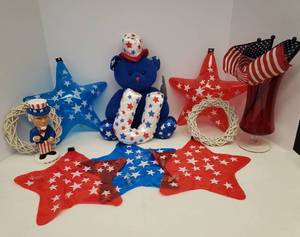 lot 151 image: Patriotic Decor New American Huggables Plush Bear, Red Flash Glass Vase 9.5in T, 4 Stick Flags, White Wicker Mini WreathsCandle Rings 6.5in W, Uncle Sam Bobble Head 7in T, and 5 Blow Up Hangable Stars 11in T