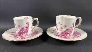 lot 105 image: (2) Royal Crown Derby Chelsea Bird demitasse cup and saucer features a detailed pink bird pattern and delicate gold rim detailing.