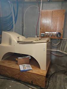 lot 935 image: Libbe Colon Hydrotherapy Machine.  Table 38 x 27 x 63.  Wall Cabinet 36 x 30 x 16.  Wood Stand 15 x 36 x 16.  Will NEED to bring tools to take apart.  Comes with boxes of lubricating jelly, rectal tubes and booklet.  Located in Basement with Walkout