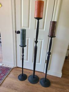 lot 1068 image: Set of 3 Tall Metal Floor Candlesticks with Pillar Candles, tallest is 57in.