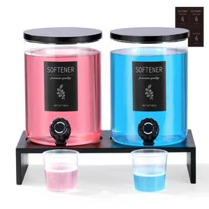 lot 5547 image: Glass Laundry Detergent Dispenser with Shelf & Black Bamboo Lid - 120 Oz Liquid Detergent, Laundry Soap & Fabric Softener Dispenser for Laundry Room Organization and Storage with 2 Cups & 8 Labels - Retail $45