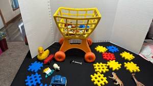lot 1395 image: Childrens shopping cart with assorted toys