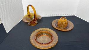 lot 1413 image: Indiana Glass Tiara Amber Sandwich glass basket, ashtray and covered candle holder