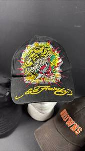 lot 100 image: Mixed Hat Lot - Louis Vuitton Bucket Hat, Ed Hardy Tiger Cap, Cleveland Browns Cap & Chicago Bulls Cap