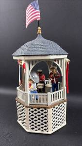 lot 18 image: Studio 56 Patriotic Band Stand Gazebo Musical Figurine with American Flag. Some Damage, Music Box works Great.