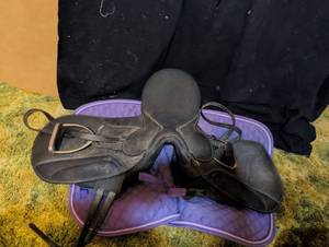 lot 324 image: Black English All-Purpose Horse Saddle with Stirrups and Purple Saddle Pad