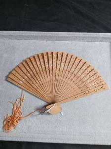 lot 50419 image: Carved Wooden Folding Hand Fan with Floral Engravings and Tassel
