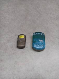 lot 323 image: Camel Branded Flip-Top Lighter and Empty Tabbaco Tin