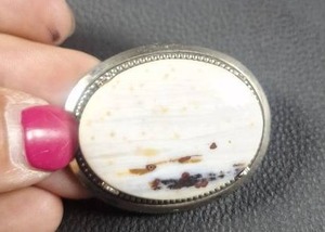 lot 12 image: Oval Brooch with White Stone and Beaded Metal Setting