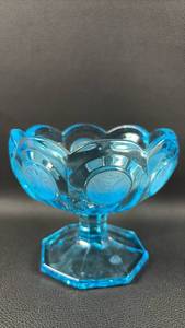 lot 40 image: Fostoria Ice Blue Coin Glass pedestal candy dish features a scalloped rim and a distinctive coin dot pattern.