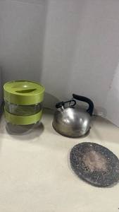 lot 1243 image: Pyrex Glass Storage Bowls with Lids, Stainless Steel Whistling Tea Kettle, and Decorative Metal Trivet Set