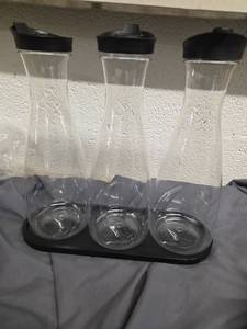 lot 563 image: Three Pack Plastic Serving Bottles with Lid and Wooden Tray - Retail $0