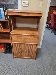 lot 38 image: Microwave Cabinet (no casters, but has holes for them) - 25 W x 19.5 D x 48.5 H.  Opening for microwave is 14 58 H. Finish in overall good condition, one small chip on upper left front corner