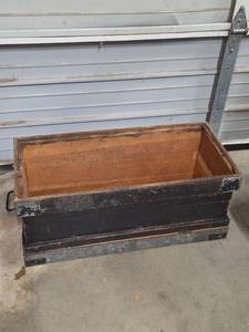 lot 39 image: Military issue chest - pictured upside down to show bottom is missing.  Could convert to a planter box.  Lid is attached on one end by a chain