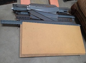 lot 896 image: Gorilla Shelving Parts - Metal Shelf Brackets and Particle Board Shelving Lot - 7 wood panels and multiple supports (some finish wear and rust)