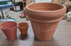lot 1006 image: Three Terracotta Planters, Large 13 inch Pot, one smaller terracotta planter, and one plastic