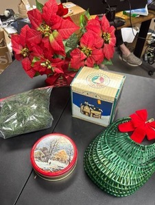 lot 504 image: Christmas Decor Lot - including Christmas Valley 1991 Collectors Series Porcelain General Store Porcelain, tins, basket, faux poinsetta and garland