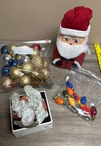 lot 514 image: Holiday & Seasonal Decor Lot - Santa Door Stop made from a shaped cinder block brick, vintage light bulbs, ornaments and clear glass nativity set with mirror base Santa Figure Ornaments Lights Nativity