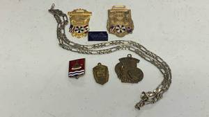 lot 38 image: Includes two large commemorative medals marked with dates and IAB symbols, one marked 1966 Detroit and another marked 1958 St Louis, plus four smaller medals. Metal chain included. Blue enamel nameplate reads Kansas City 1886-1986 On The Kansas Side.