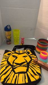 lot 1125 image: Mixed Novelty Lot lion king Tote Bag, Sesame Street Tumbler, Tiki Cup, Slinky, Solar Figure